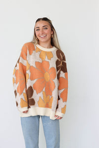 girl wearing brown and orange floral sweater