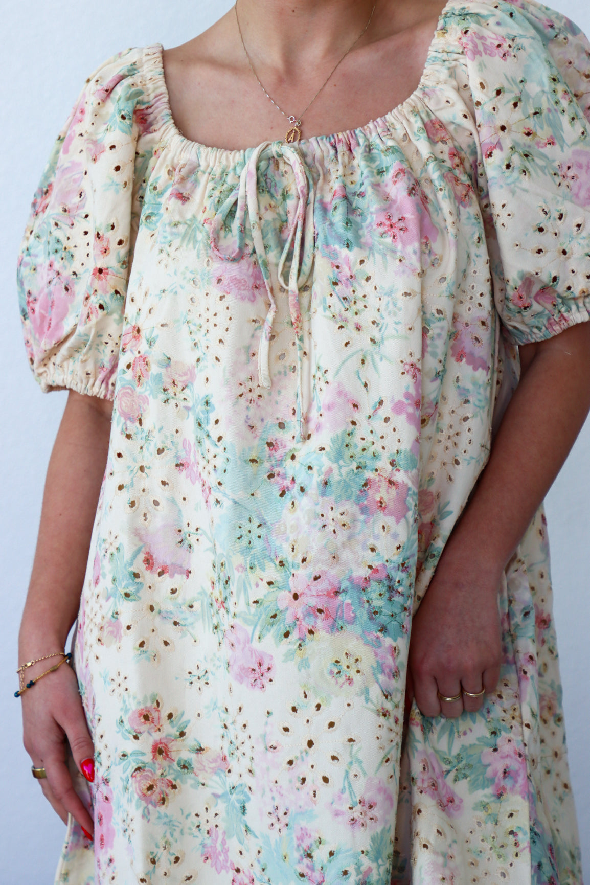 Floral dress with puff sleeves worn by a person on a plain background