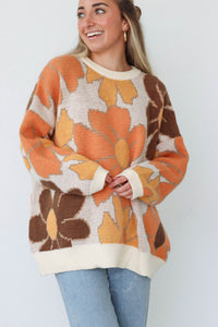 girl wearing brown and orange floral sweater