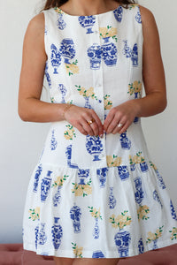 White dress with blue floral patterns on a plain background