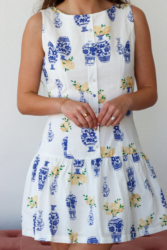 White dress with blue floral patterns on a plain background