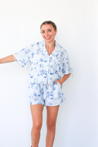 Woman wearing a blue and white pajama set against a white background