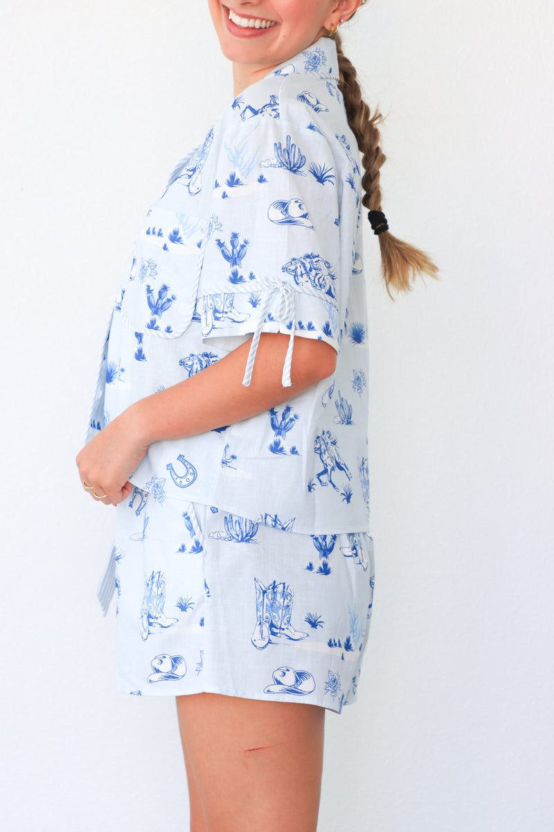 Woman wearing a blue and white patterned shirt with a plain background