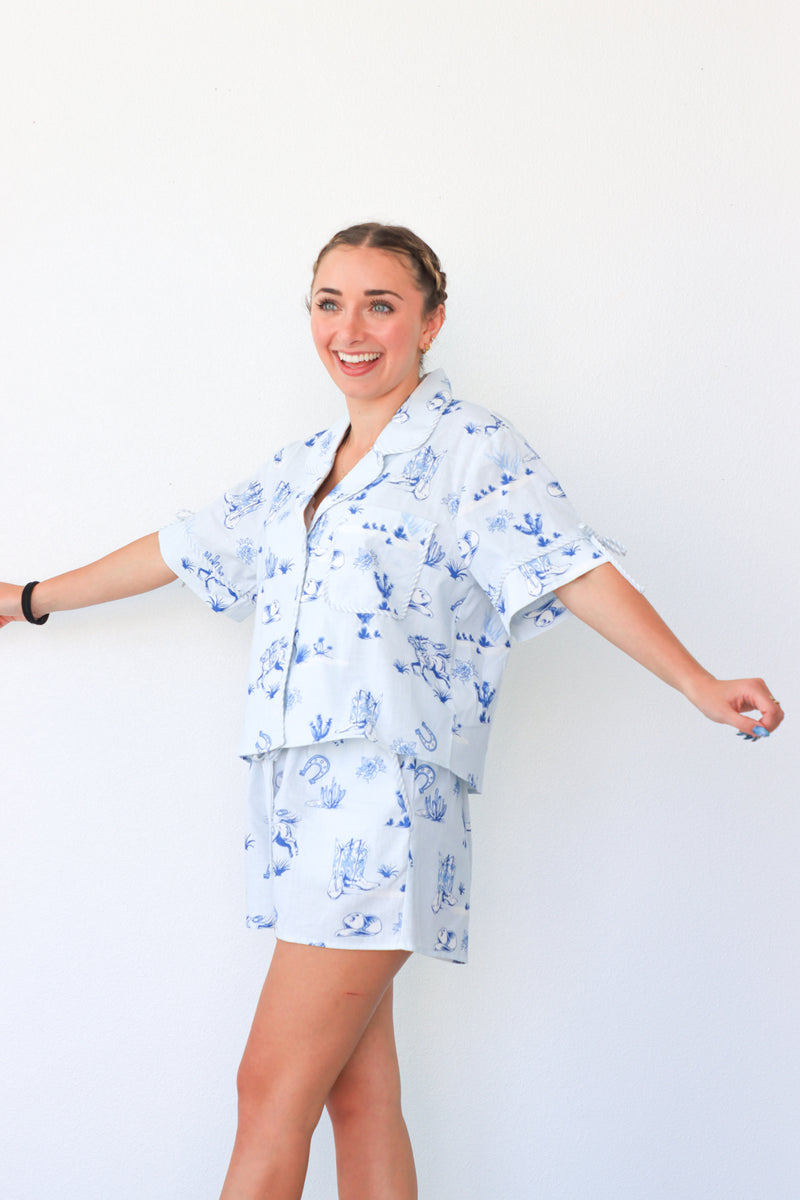 Woman wearing a blue and white patterned pajama set against a white background