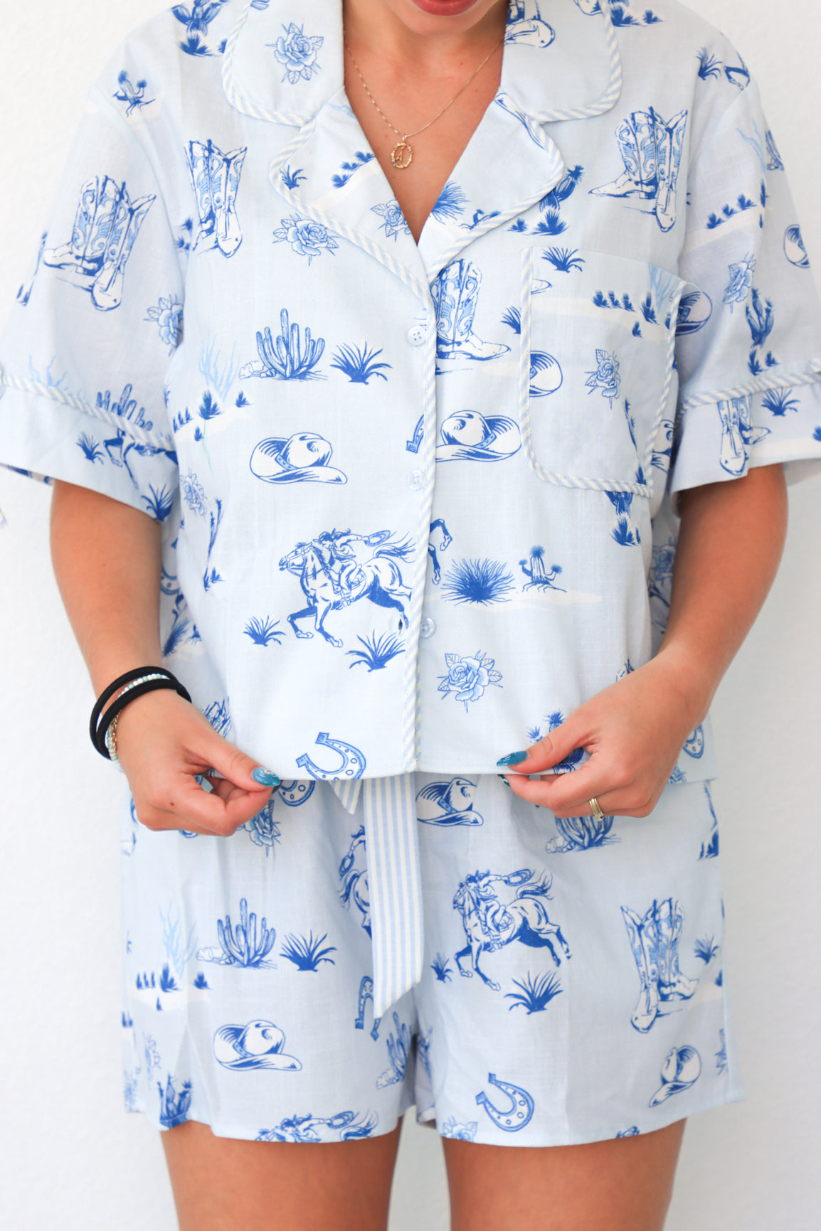 Person wearing a white outfit with blue animal print on a plain background