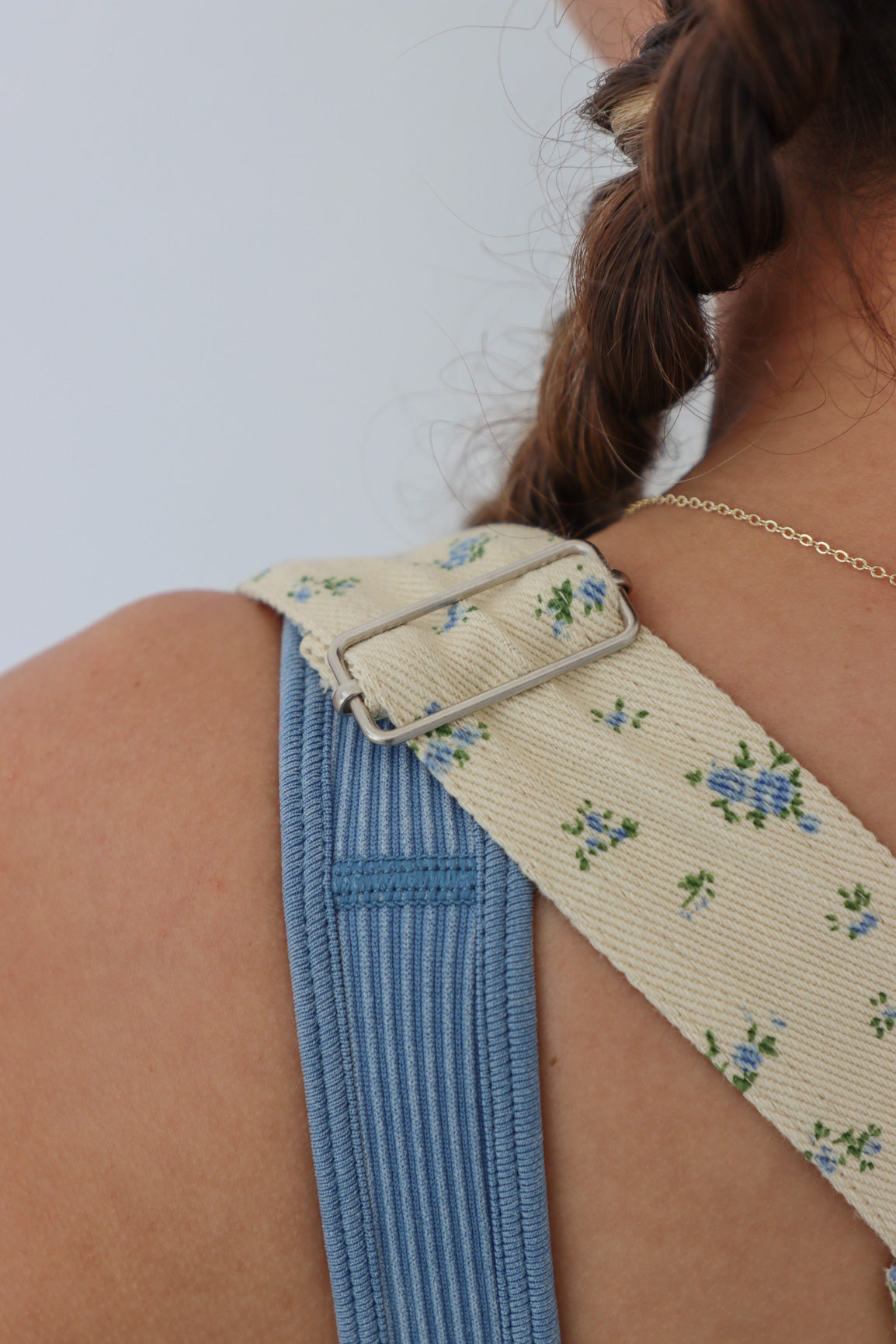 girl wearing yellow floral short overalls