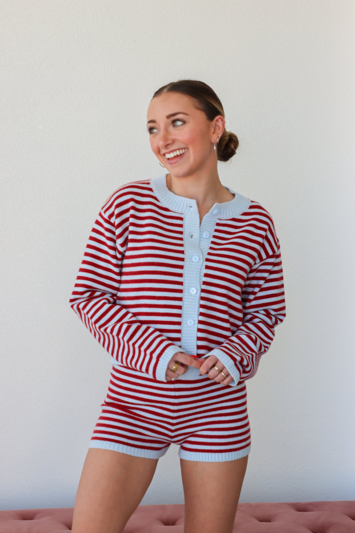 Woman wearing a red and white striped outfit against a plain background
