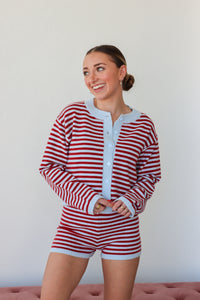 Woman wearing a red and white striped outfit against a plain background