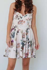 girl wearing white short dress with multicolored floral print