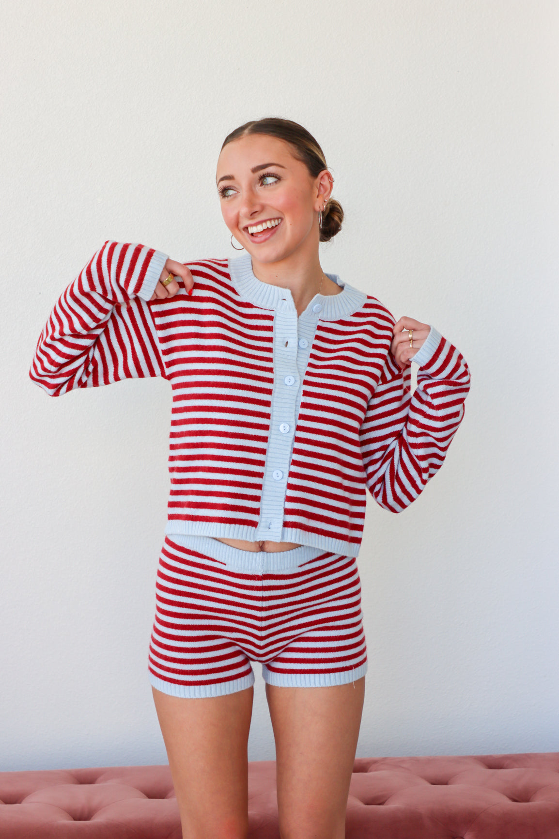 Woman wearing a red and white striped outfit against a plain background