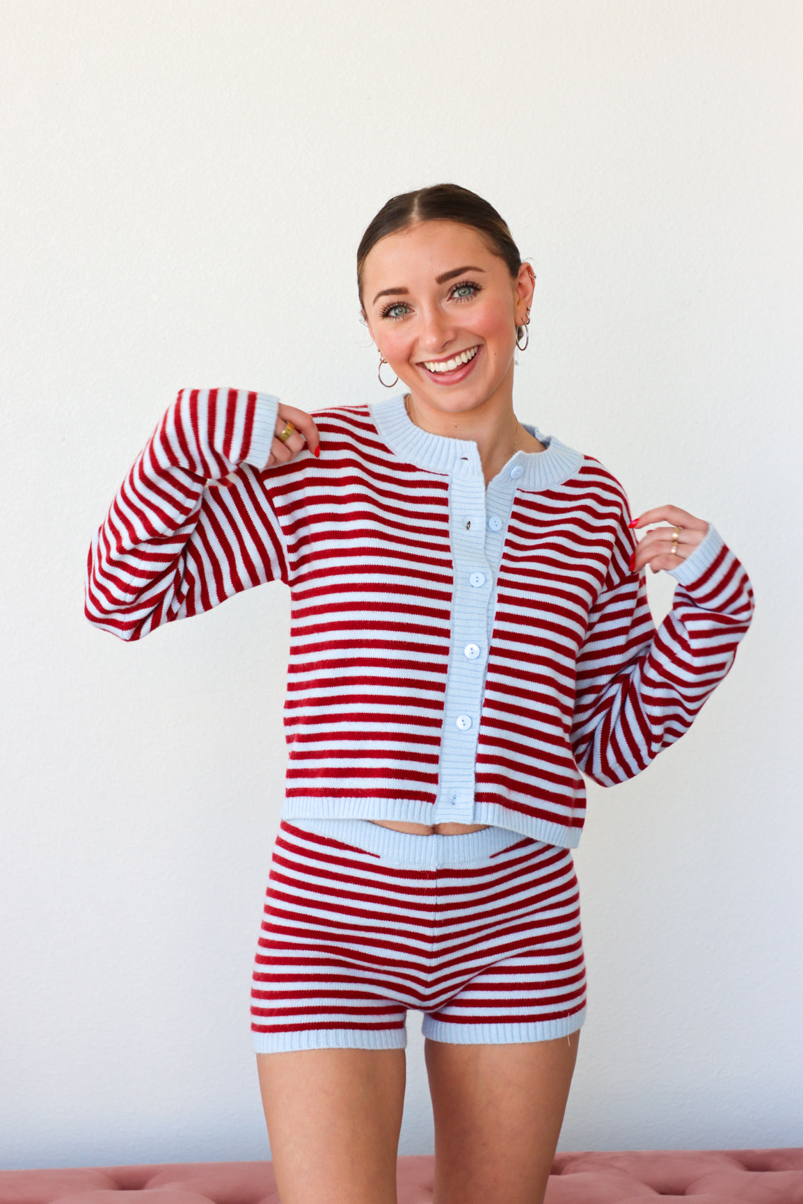 Woman wearing a red and white striped outfit with a white background