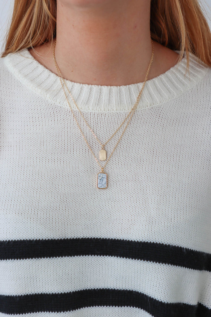 gold layered necklace with a white marble pendant charm