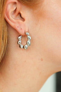 girl wearing silver scalloped hoop earrings