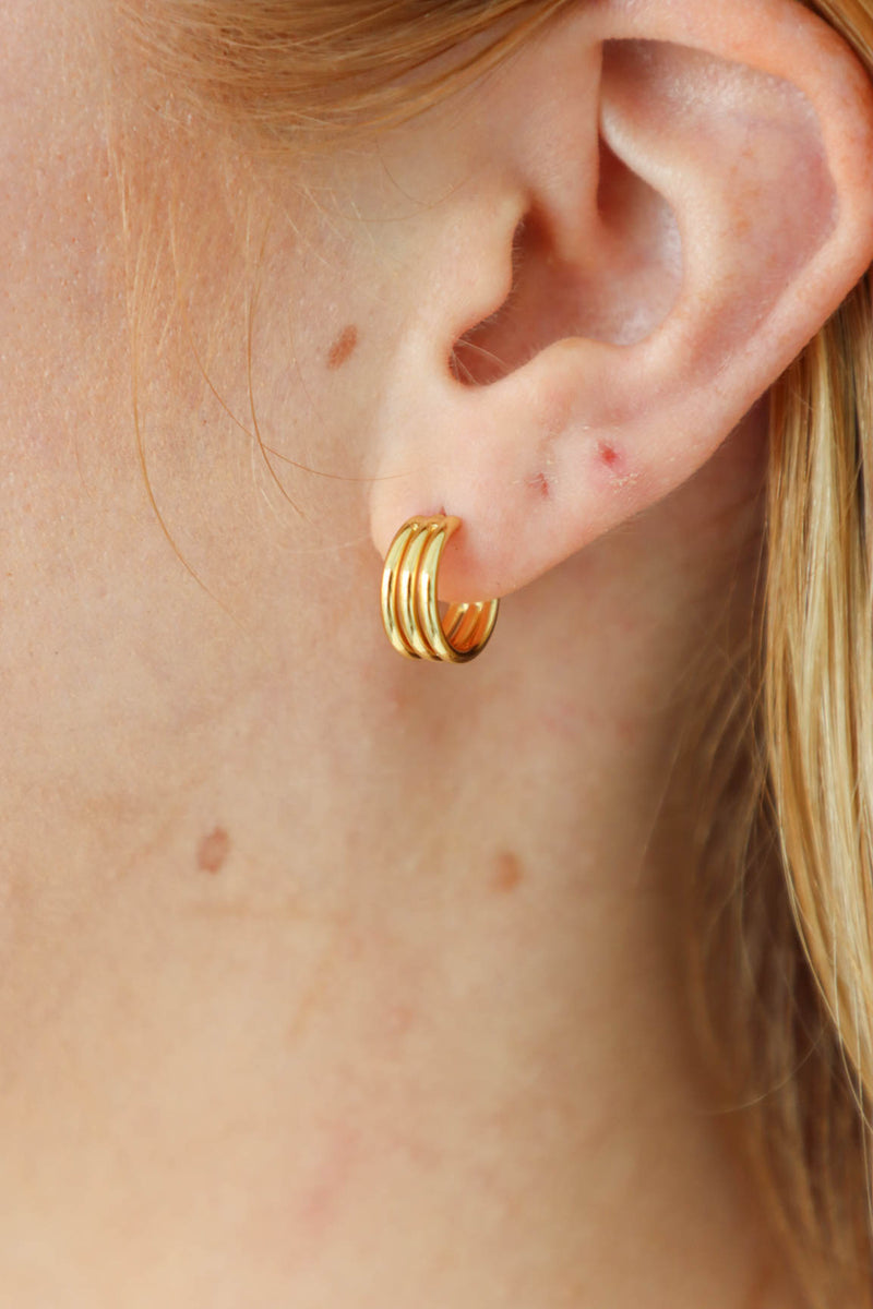girl wearing gold mini hoop earrings