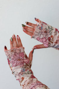 Floral patterned gloves worn on a white background