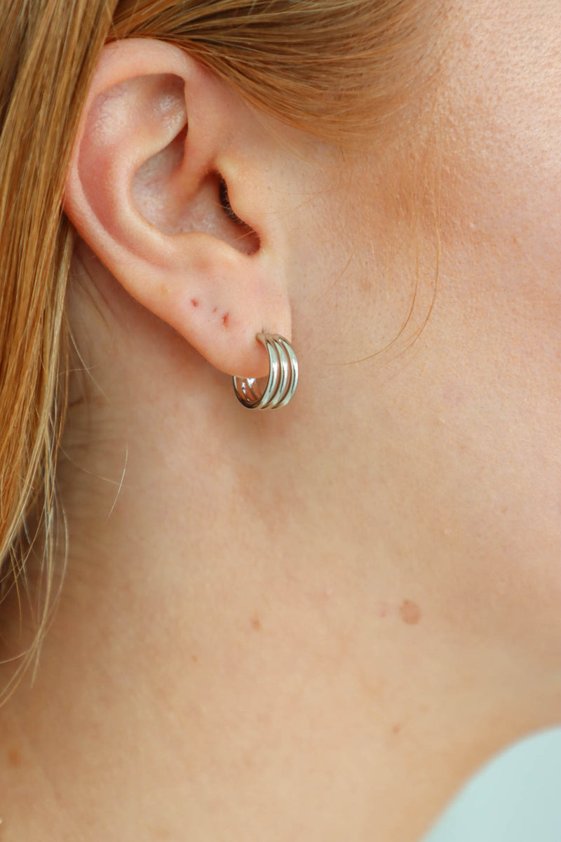 girl wearing silver mini hoop earrings