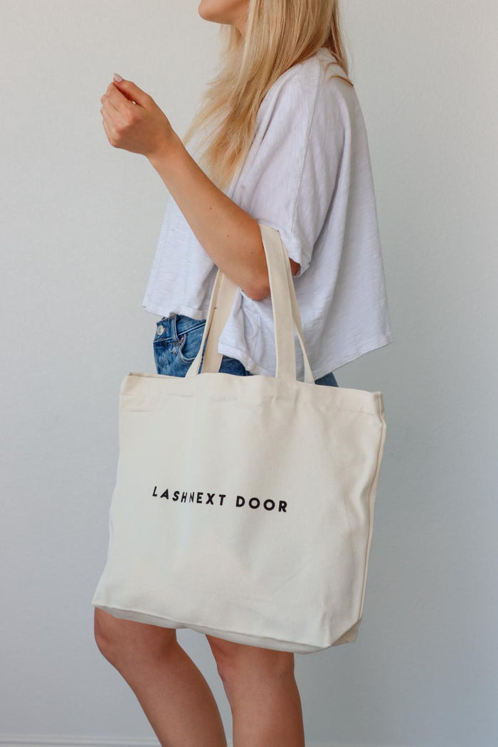 girl carrying "lash next door" canvas tote bag
