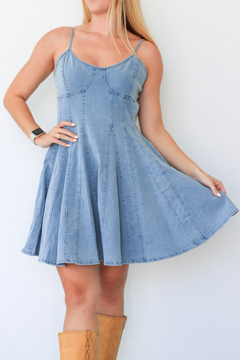Woman wearing a denim dress with a plain background
