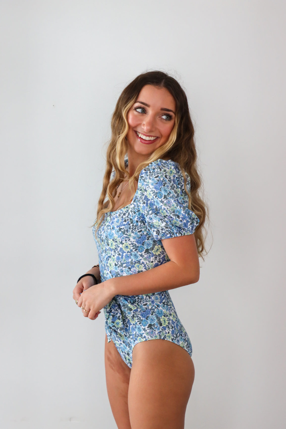 girl wearing blue floral cap sleeve one piece swimsuit