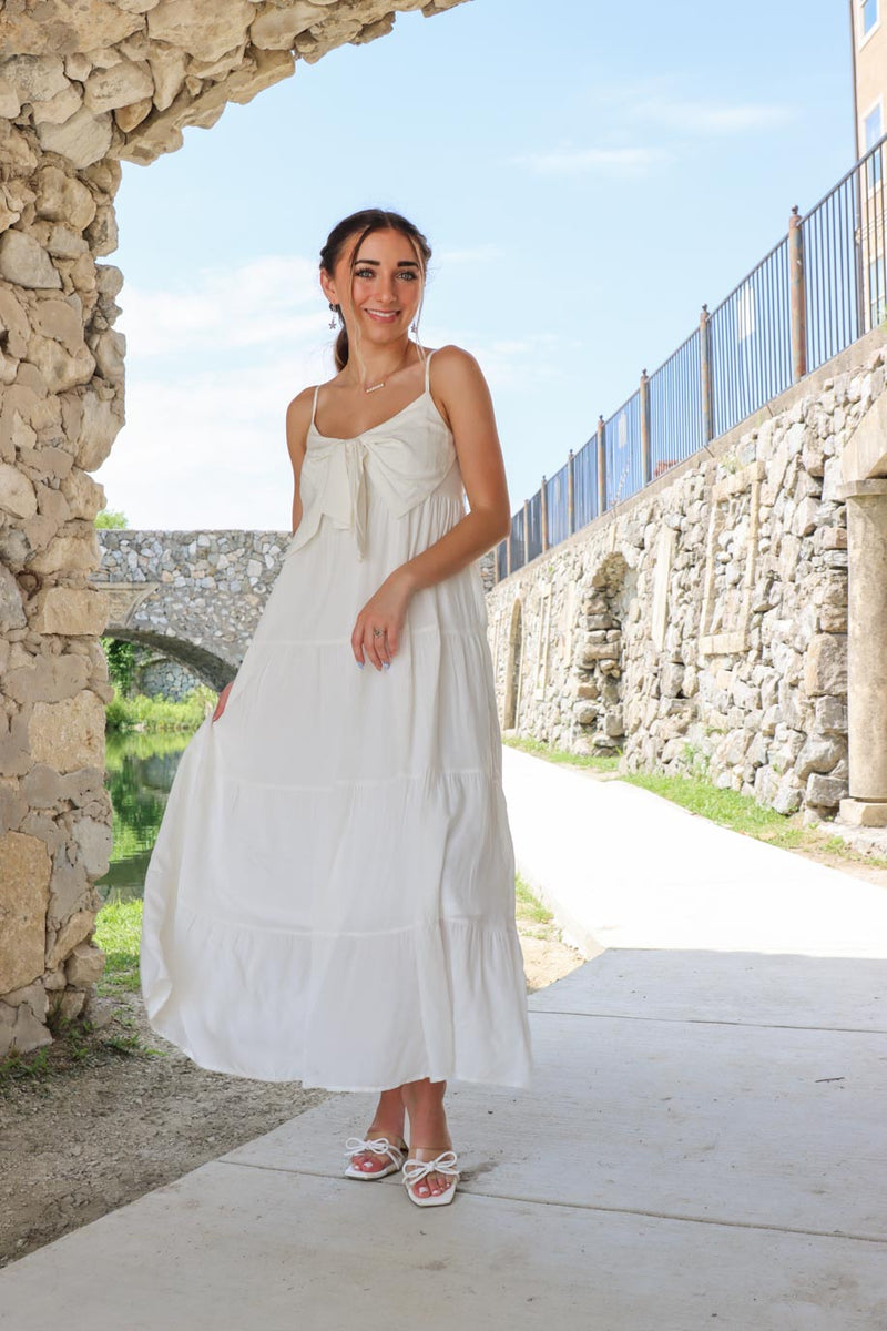 girl wearing white long maxi dress with bow detailing