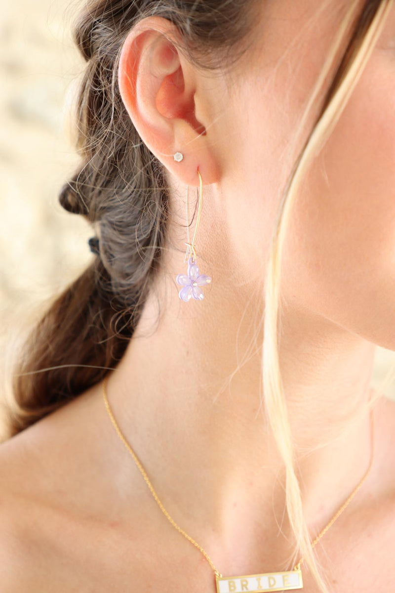 girl wearing purple crystal flower earrings