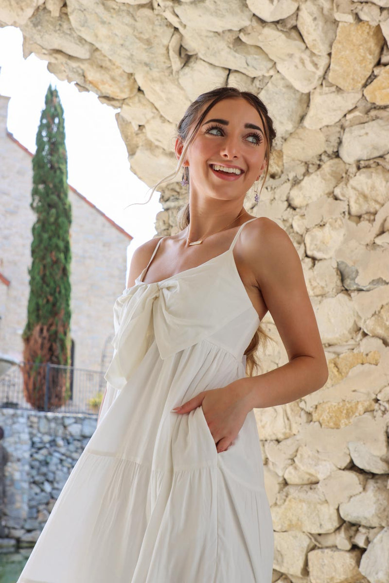 girl wearing white long maxi dress with bow detailing and functional pockets