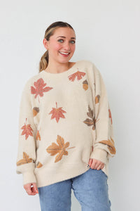 girl wearing cream sweater with leaf pattern