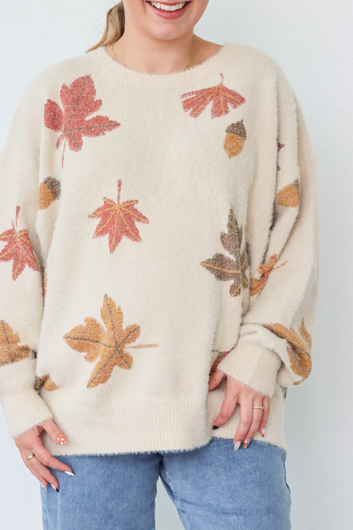 girl wearing cream sweater with leaf pattern