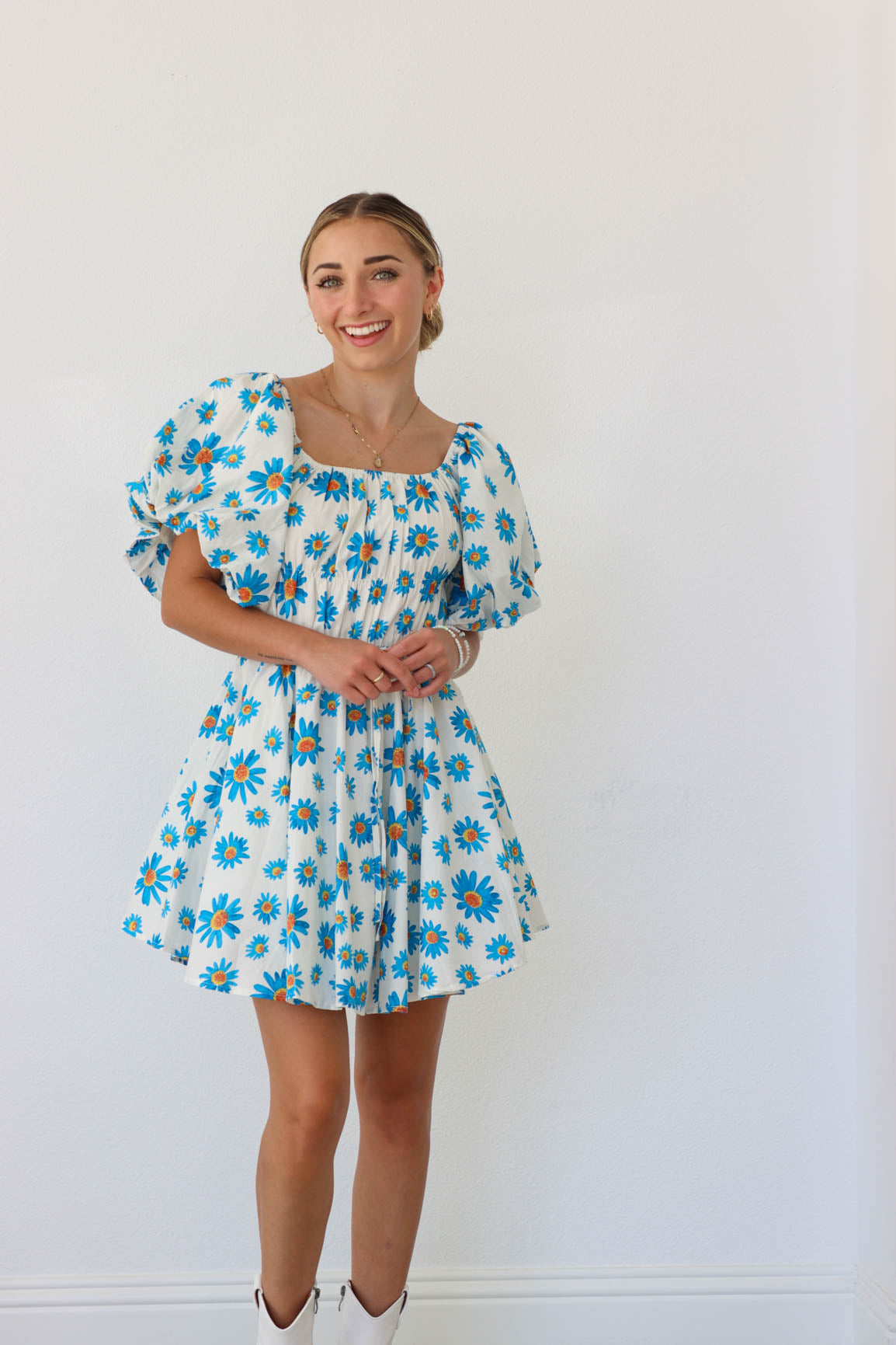 girl wearing white puff sleeved dress with blue florals 