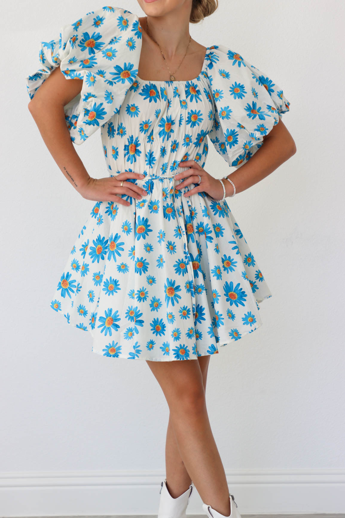 girl wearing white puff sleeved dress with blue florals 