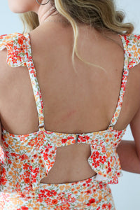 Woman wearing a floral dress with cut-out design on a white background