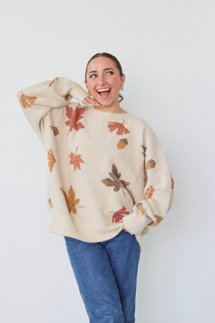 girl wearing cream sweater with leaf pattern