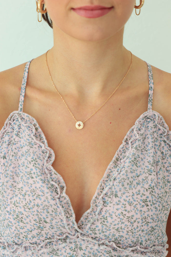 girl wearing gold compass necklace