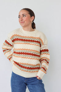 girl wearing cream multicolored knit sweater