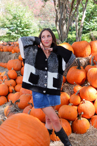 Woman wearing a black and white patterned cardigan