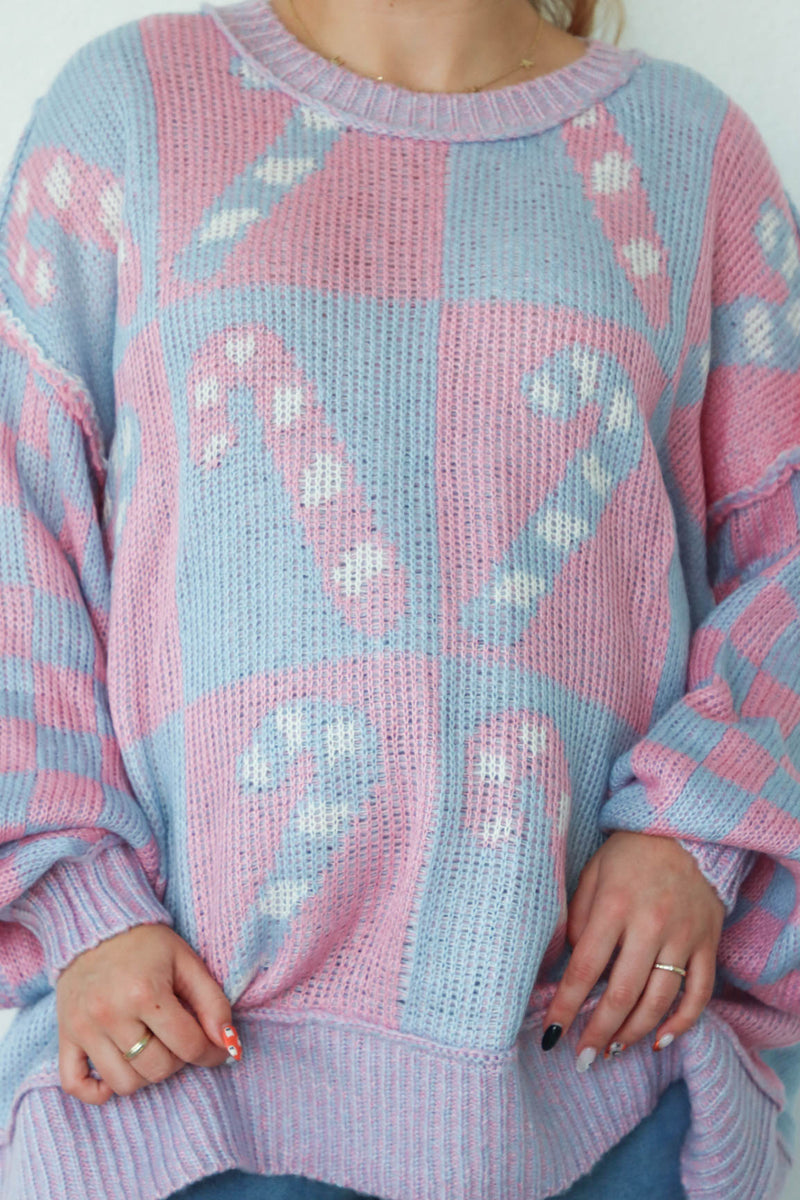 girl wearing periwinkle and pink candy cane sweater