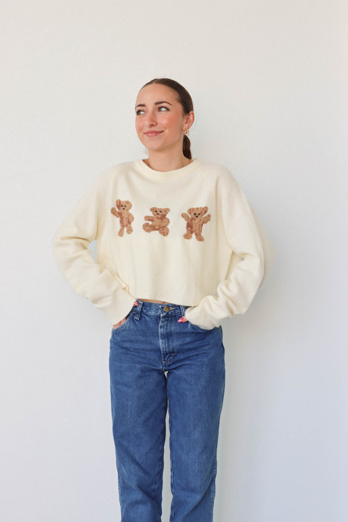 girl wearing cream bear sweater