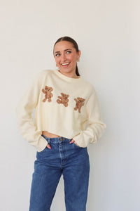 girl wearing cream bear sweater