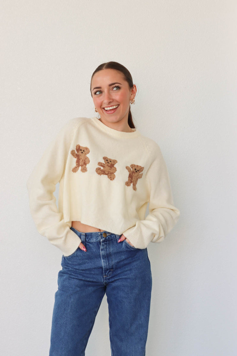 girl wearing cream bear sweater