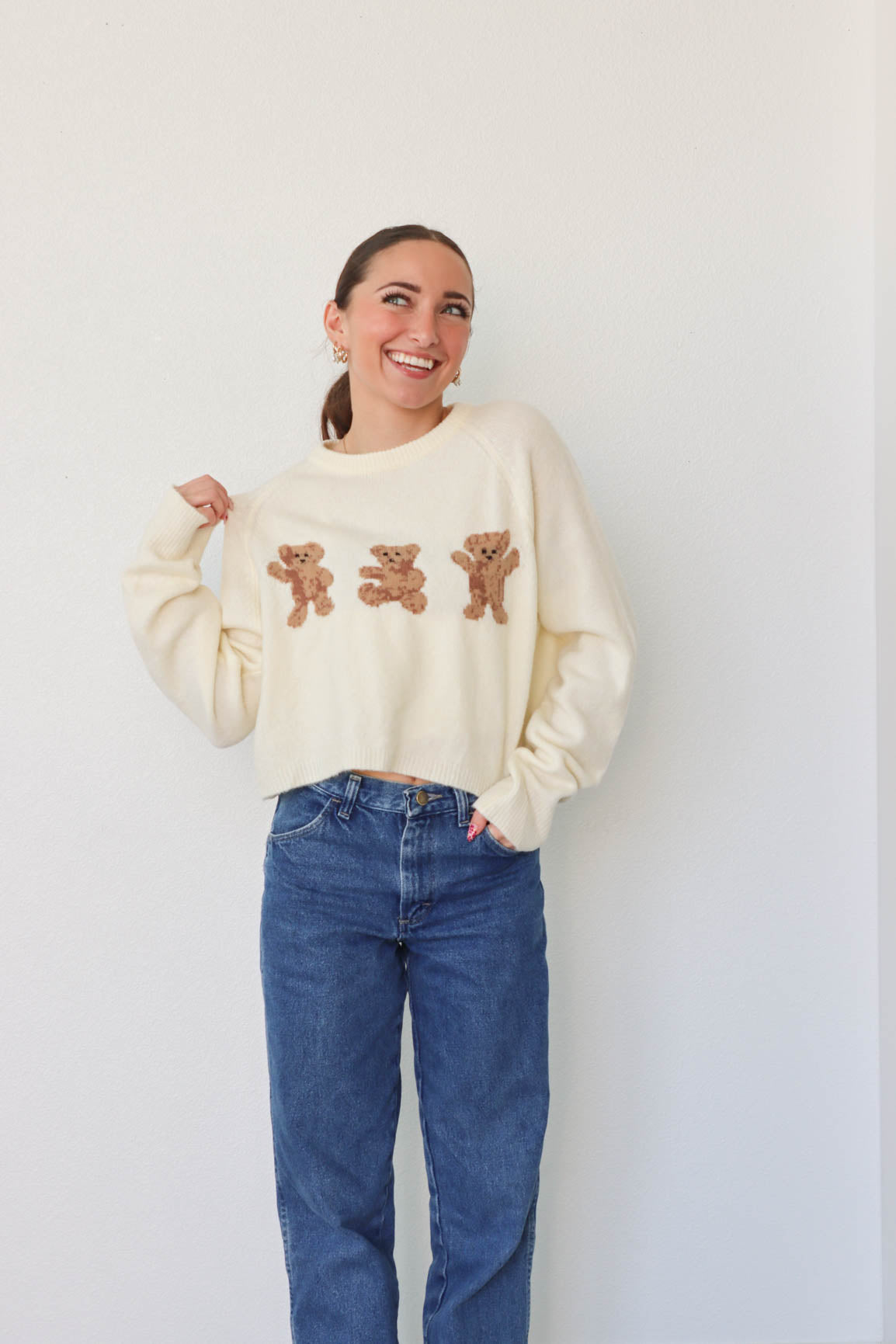 girl wearing cream bear sweater