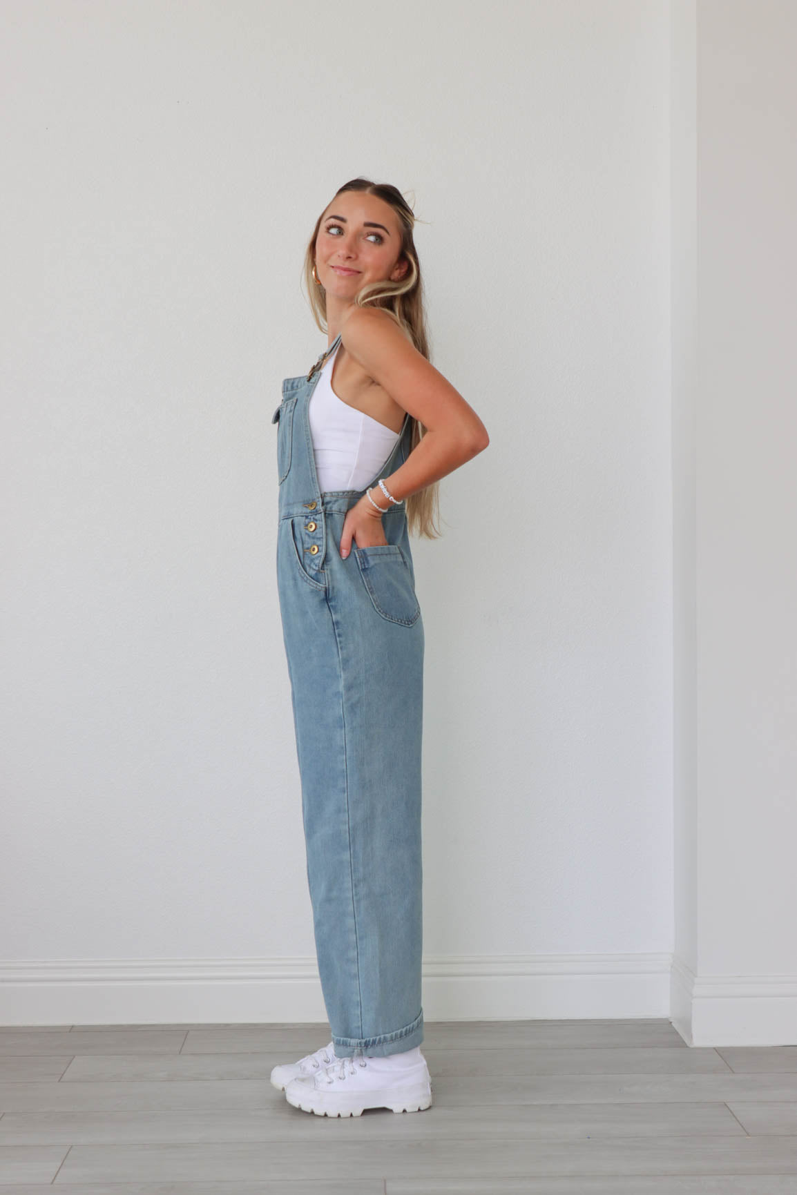 girl wearing light wash denim overalls