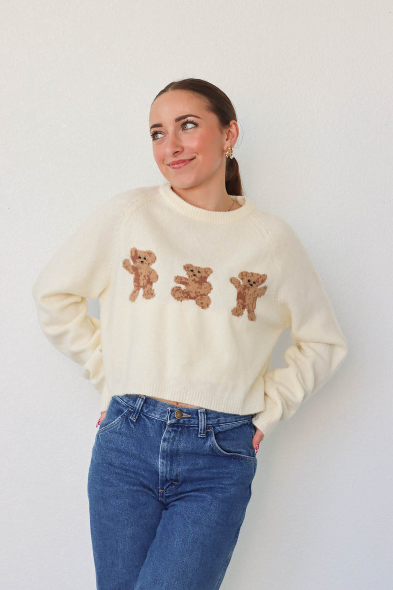 girl wearing cream bear sweater