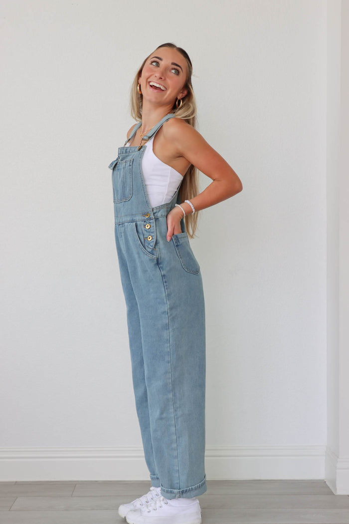 girl wearing light wash denim overalls