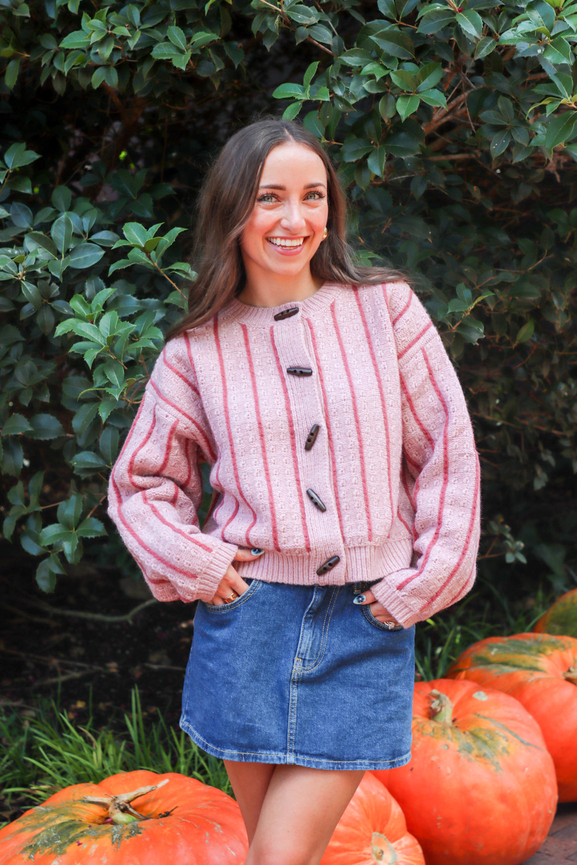 Woman wearing a pink and red striped sweater with buttons