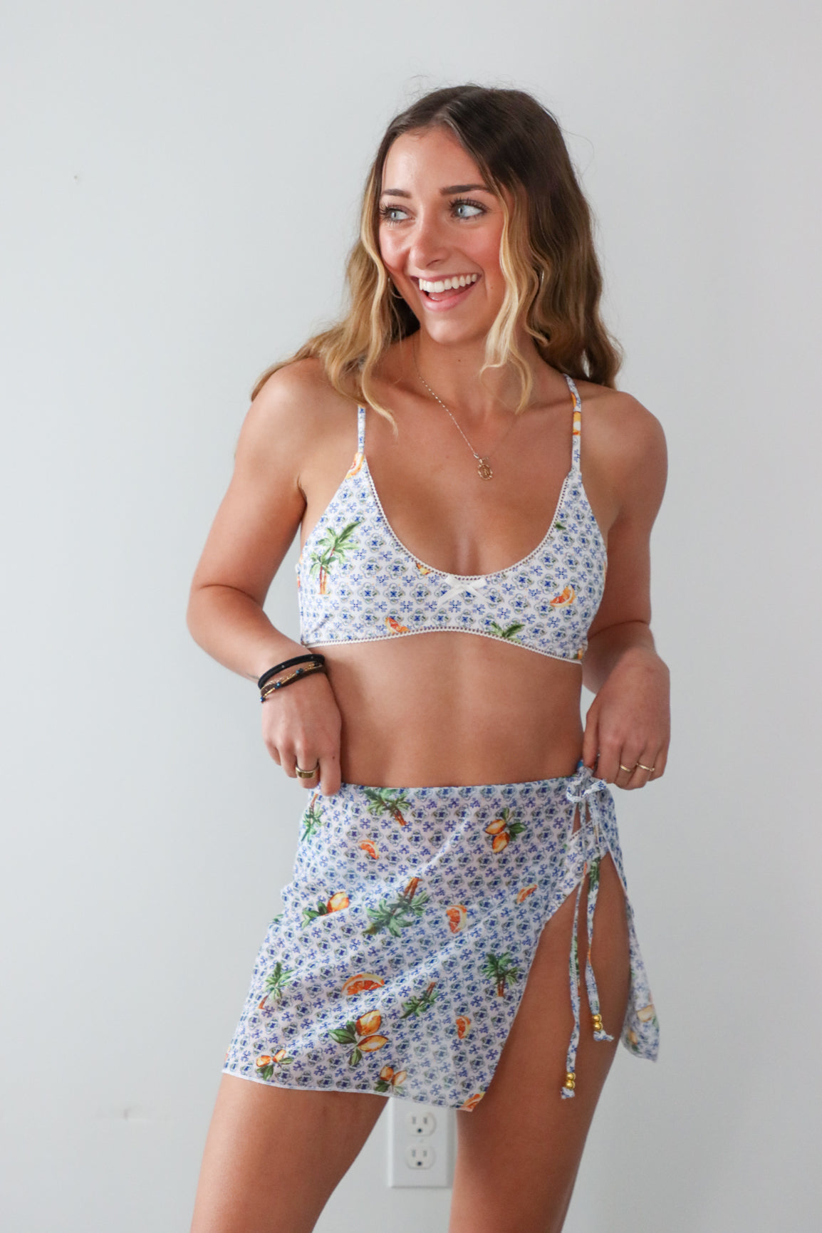 Woman wearing a floral two-piece swimsuit against a plain background