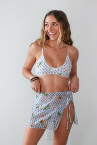 Woman wearing a floral two-piece swimsuit against a plain background
