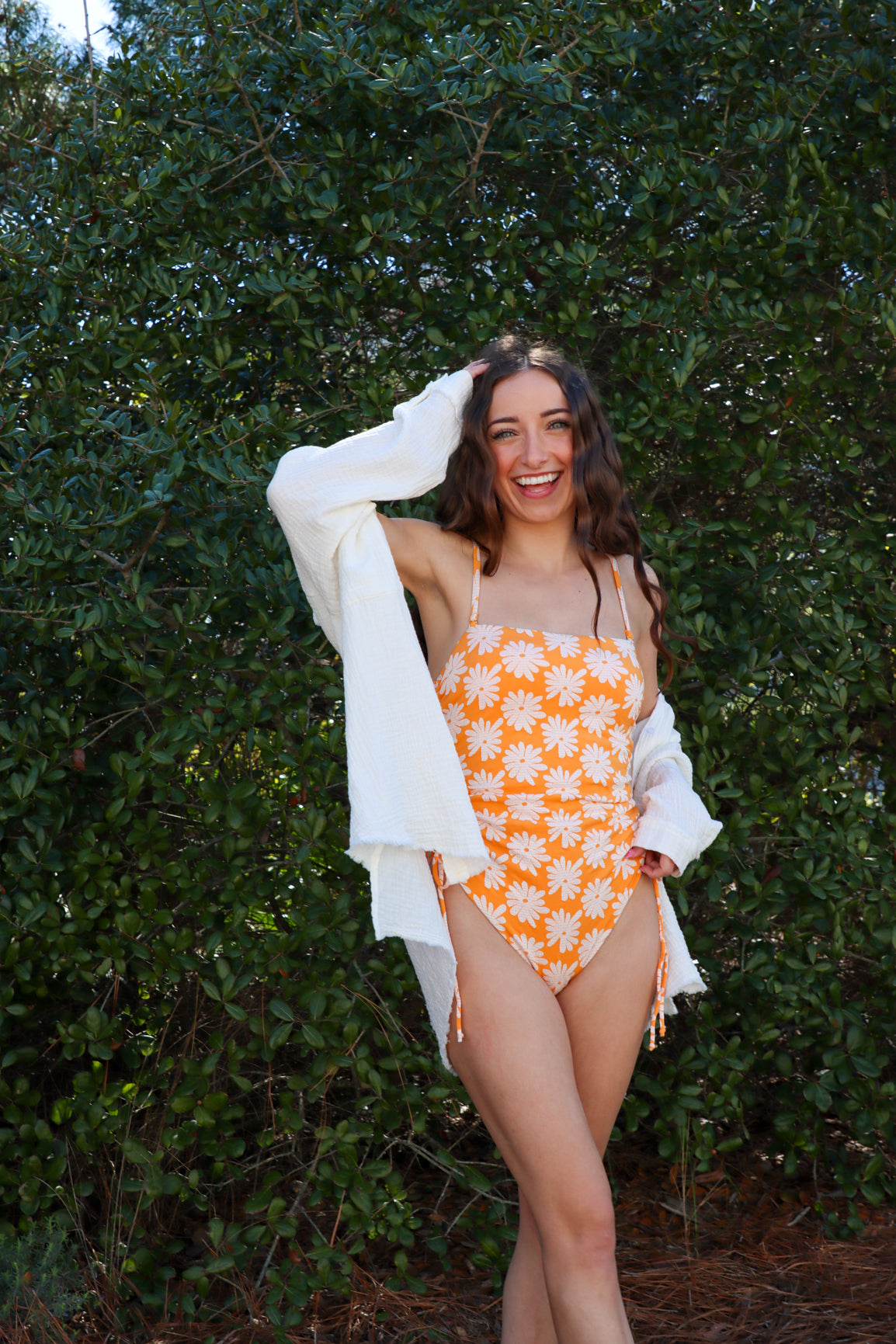 girl wearing orange floral one piece swimsuit