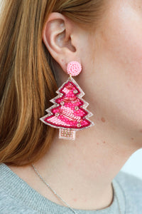 girl wearing pink christmas tree beaded earrings