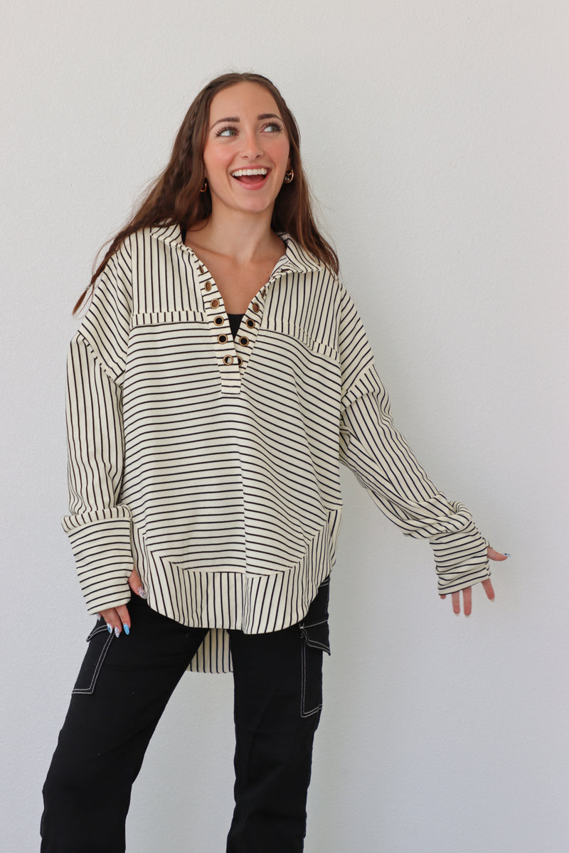 girl wearing cream pullover with black stripes