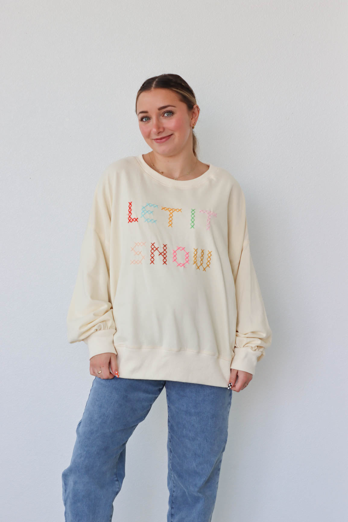 girl wearing cream "let it snow" top